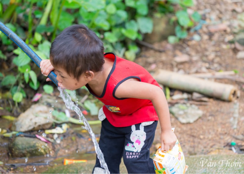 Boy drinking water from pipe